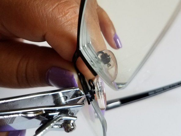 Knip nu de extra draad aan beide kanten van de bril af met de nagelknipper.' alt=
