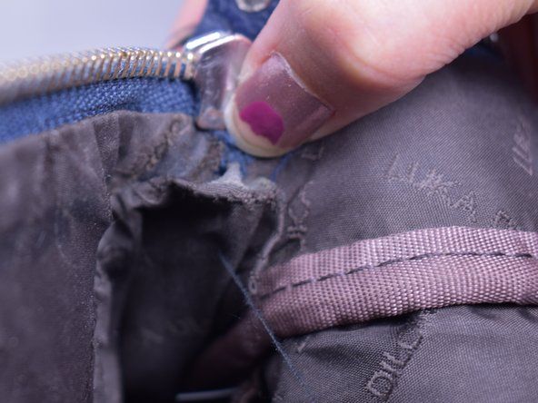 Letakkan ritsleting di dalam penutup beg galas untuk menutup hujung zip.' alt=