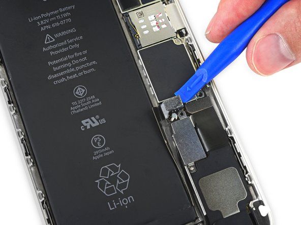 S čistim nohtom ali robom orodja za odpiranje nežno povlecite konektor baterije iz vtičnice na logični plošči.' alt=