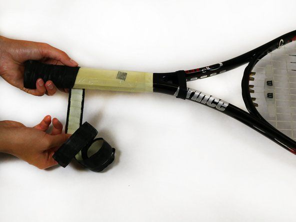 Beberapa raket tenis yang lebih tua mungkin memiliki beberapa staples yang menahan grip ke buttcap. Gunakan penghilang staples untuk mengeluarkannya.' alt=