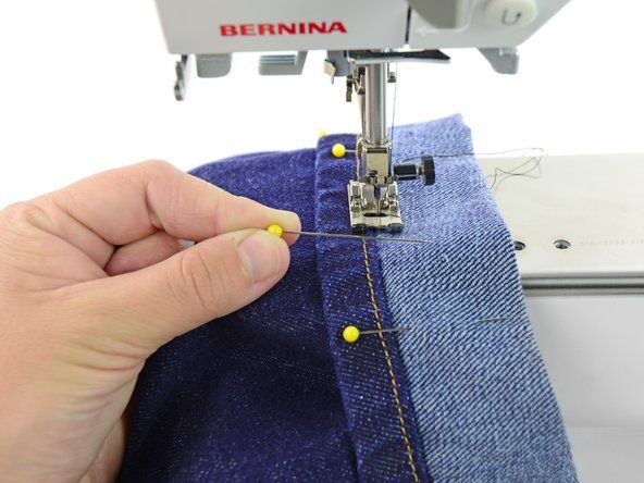 Naai nooit over pinnen. Als de naald van de naaimachine een speld raakt, kan deze buigen of breken.' alt=