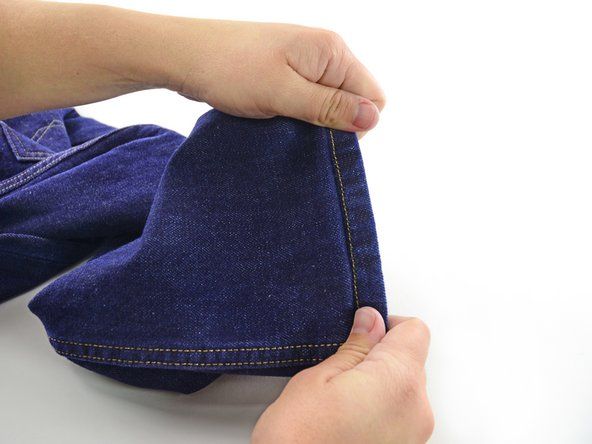 Fold jeansene ud, og læg den fold, du lige syede, ind i buksebenet.' alt=