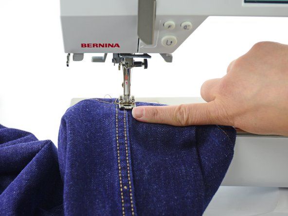 Forsikre deg om at buksebenet er rundt armen på symaskinen, slik at du ikke gjør det' alt=
