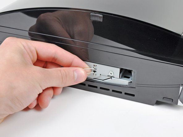 Pak het treklipje van de harde schijf vast en trek de harde schijf naar de voorkant van de PS3.' alt=