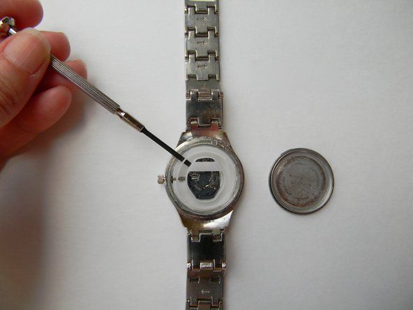 Ota valkoinen muovirengas kellosta. Voit vetää mini-litteällä ruuvimeisselillä tai sormellasi sen ulos.' alt=