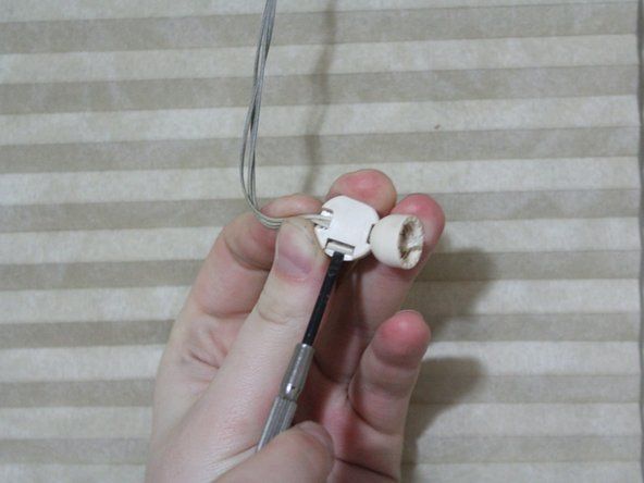 Brug en flad skruetrækker til at åbne ledningsstoppet, fjerne det fra strengene og lægge det til side.' alt=