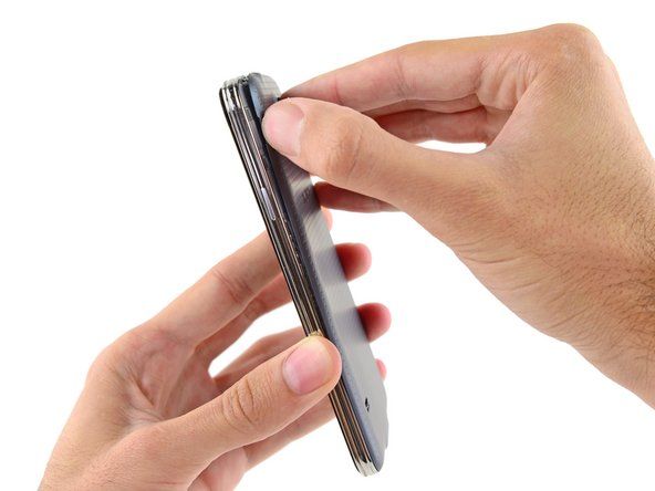 Lirk forsiktig og vri det fleksible bakdekselet av baksiden av telefonen.' alt=