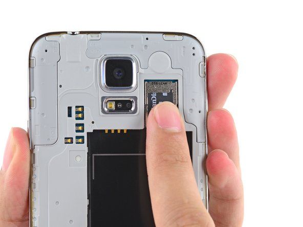 Usando a ponta do dedo, puxe o cartão microSD diretamente para baixo para fora do slot.' alt=