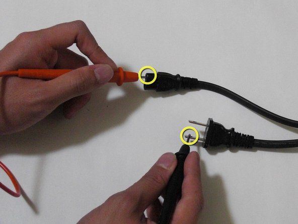 Otestujte potenciální otevřený obvod pomocí jednoho kabelu multimetru, který se dotkne jednoho z hrotů na AC straně napájecího kabelu. Druhým kabelem se dotkněte jednoho konce napájecí šňůry na straně konzoly.' alt=