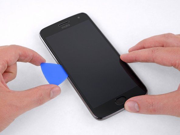 Гурните алат по левој ивици телефона, прорезујући лепак који осигурава екран.' alt=
