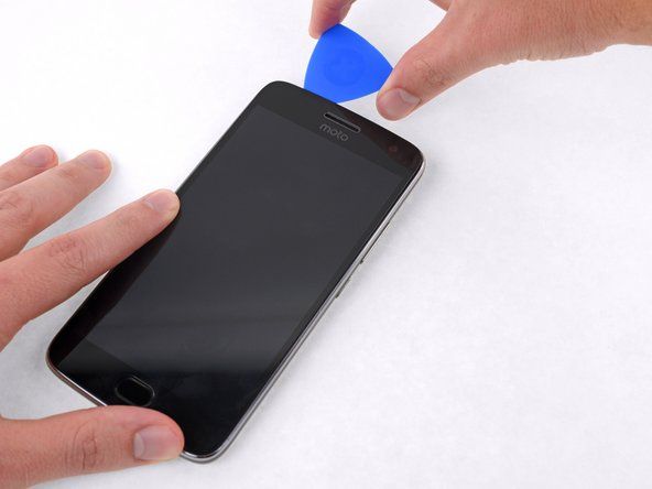 Наставите са резањем лепка на горњој и десној страни телефона.' alt=