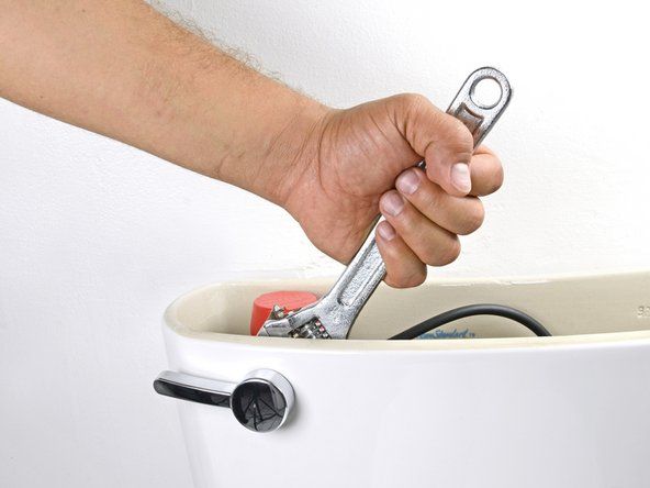 Χρησιμοποιώντας ένα ρυθμιζόμενο κλειδί, γυρίστε το παξιμάδι στη λαβή της τουαλέτας δεξιόστροφα μέχρι να χαλαρώσει.' alt=