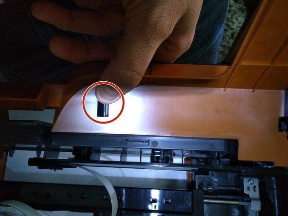 Prilikom ponovnog sastavljanja provjerite je li bijeli ravni kabel vrpce pravilno pričvršćen. Ako nije pravilno pričvršćen, nećete moći zatvoriti narančasti poklopac.' alt=