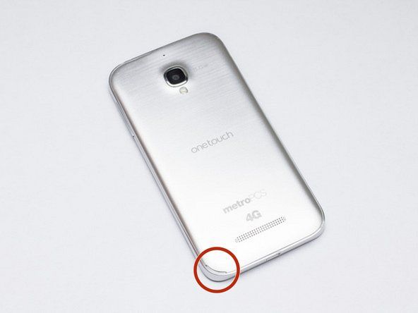 電話の左下隅にあるディボットで、プラスチック製のオープニングツールまたは指の爪でこじ開けます。' alt=