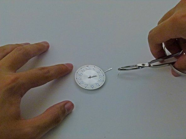 Zatlačte na ruku tak, aby hodinová ručička byla pevně připevněna ke středovému sloupku.' alt=