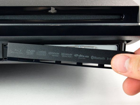 Csúsztassa a merevlemez-meghajtó fedelét az alsó burkolat jobb oldala felé, majd húzza le az elülső szélétől, hogy eltávolítsa a PS3-ból.' alt=