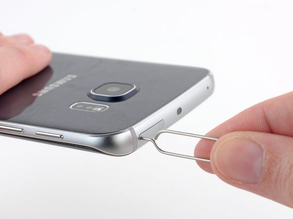 Vložte kancelářskou sponku nebo nástroj pro vysunutí SIM do otvoru ve slotu pro SIM kartu v horní části telefonu.' alt=