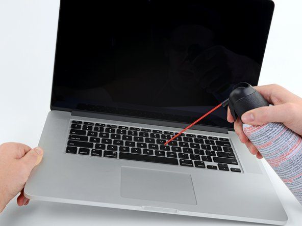 Om du märker något som sitter fast under en viss nyckel, försök luta den bärbara datorn i olika vinklar medan du blåser tryckluften för att få ut den. Laptopnycklar har små kanter på sig som kan fånga skräp.' alt=