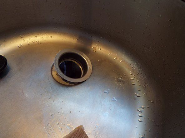 За да премахнете фланеца, ще избутате отдолу под мивката с една ръка и ще я издърпате през горната част на мивката с другата ръка.' alt=