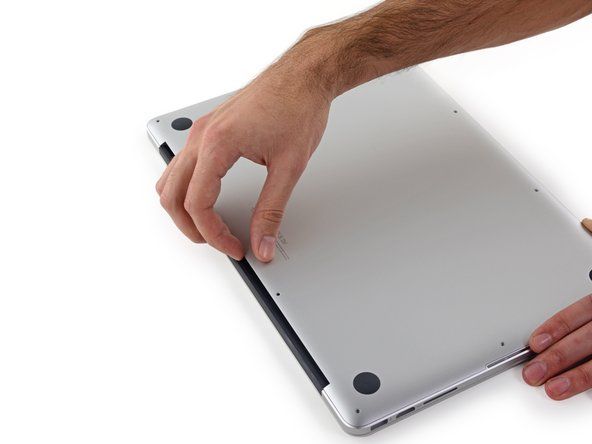 Dvignite z roba, ki je najbližji pokrovu sklopke, dvignite spodnji del ohišja MacBook Pro.' alt=