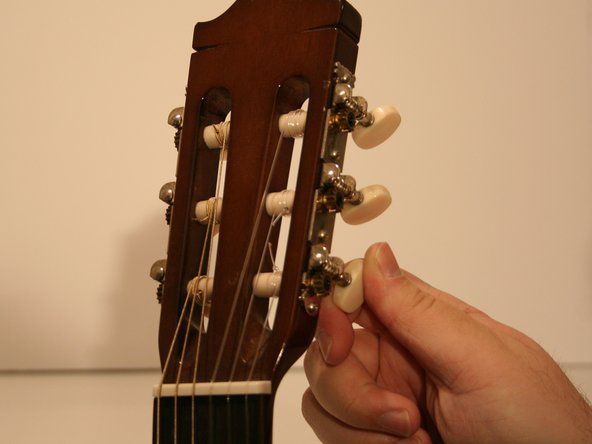 Xoay bộ đếm chốt điều chỉnh theo chiều kim đồng hồ để nới lỏng tất cả các dây đàn guitar.' alt=