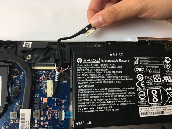Opatrně odpojte kabel spojující horní část baterie a vyjměte baterii.' alt=