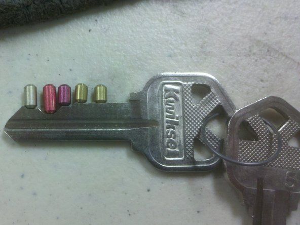 Untuk memasang semula silinder, lepaskan pin bawah dari plag dan ganti dengan pin bersaiz yang sesuai untuk kunci baru.' alt=
