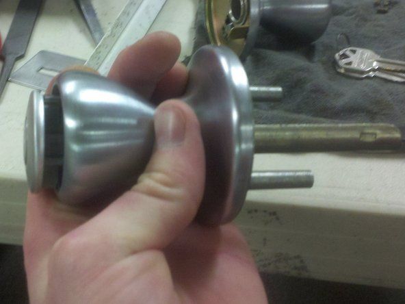 Pousser doucement l'extrémité de l'outil de retrait de cylindre à l'arrière de la serrure devrait déloger le cylindre du reste de la serrure.' alt=