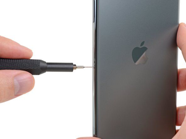 Chèn công cụ đẩy thẻ SIM hoặc kẹp giấy vào lỗ nhỏ trên khay thẻ SIM, nằm gần nút bên trên cạnh của iPhone.' alt=