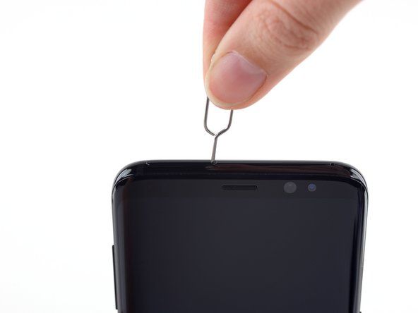 SIM 카드 열기 도구를 휴대폰 상단 가장자리의 왼쪽에있는 작은 구멍에 삽입합니다.' alt=
