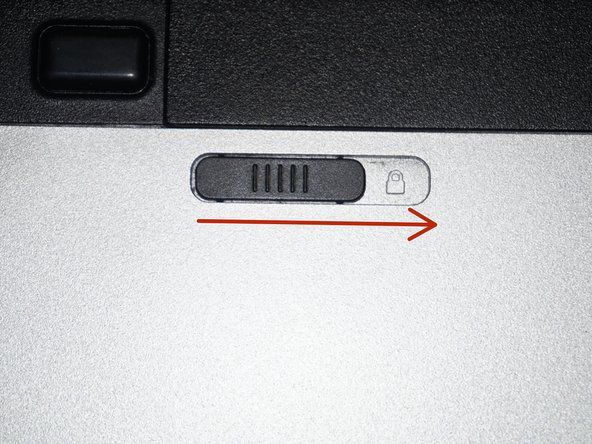 Une fois l'ordinateur éteint, retirez la batterie. Mettez la languette de verrouillage en position déverrouillée.' alt=