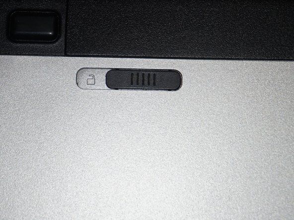 Setelah komputer mati, lepaskan baterainya. Alihkan tab pengunci ke posisi tidak terkunci.' alt=