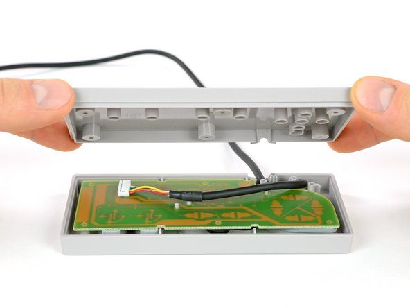 このコントローラーのネジはすぐに見えます。ここにはゴム製のプラグはありません。内部には、単一のコネクタを備えたベアボードがあります。' alt=