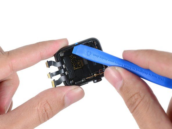 Å ta et åpningsverktøy av plast til kanten av klokken avslører en Force Touch-sensor og pakning som ligner på den som ble funnet i den opprinnelige modellen.' alt=