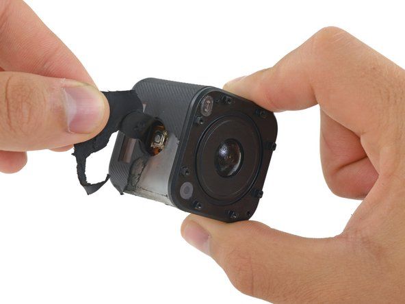 V horní části fotoaparátu je tlačítko spouště integrováno do gumového krytu a otvor v plastovém pouzdru pod ním odhaluje mikrospínač.' alt=